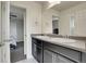 Bathroom features double sinks with dark cabinetry and mirrors, with an open door to the bedroom at 428 Starline Ave, Lafayette, CO 80026