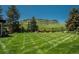 Manicured backyard features large grass area with mountain views in the background at 17326 W 57Th Ave, Golden, CO 80403