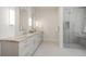 Bright bathroom with double sinks, marble countertops, sleek mirrors, and a glass enclosed shower with seating at 17326 W 57Th Ave, Golden, CO 80403