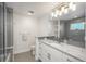 Bright bathroom featuring a marble vanity top, sleek fixtures and a frameless shower at 17326 W 57Th Ave, Golden, CO 80403