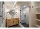 Stylish bathroom with a wood vanity, round mirror and glass enclosed shower at 17326 W 57Th Ave, Golden, CO 80403