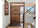 Inviting foyer featuring a wood door, sleek hardware, and contemporary staircase at 17326 W 57Th Ave, Golden, CO 80403