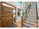 Bright foyer featuring a modern staircase, wooden front door with glass, light hardwood floors, and contemporary lighting at 17326 W 57Th Ave, Golden, CO 80403