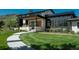 Beautiful modern home with manicured lawn and stone accents, highlighting the inviting entrance and well-maintained landscape at 17326 W 57Th Ave, Golden, CO 80403