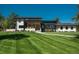 Stunning modern home showcasing a sprawling green lawn, stone accents, and a walkway leading to the inviting front entrance at 17326 W 57Th Ave, Golden, CO 80403