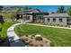 Expansive modern home with lush front lawn, a winding walkway, and charming stone accents, showcasing curb appeal at 17326 W 57Th Ave, Golden, CO 80403