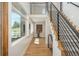 Bright, open hallway featuring hardwood floors, modern black railings, and natural light, offering a stylish transition at 17326 W 57Th Ave, Golden, CO 80403