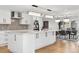 Open-concept kitchen with island seating, modern lighting, and dining area views at 17326 W 57Th Ave, Golden, CO 80403