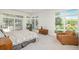 Bright main bedroom featuring large windows, a comfortable chair, and views of the landscaped outdoors at 17326 W 57Th Ave, Golden, CO 80403
