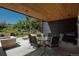 Inviting covered patio featuring a modern table set, stone accents, and views of the lush, green surroundings at 17326 W 57Th Ave, Golden, CO 80403