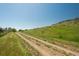 View of the property featuring a long driveway leading to the home on a hill at 17326 W 57Th Ave, Golden, CO 80403