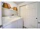 Bright laundry room featuring a washer, dryer, and extra shelving for storage at 13033 Grant E Cir # B, Thornton, CO 80241