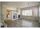 Bright living room with a fireplace, large windows, and open layout leading into the kitchen at 13033 Grant E Cir # B, Thornton, CO 80241