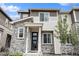 Charming townhome with stone facade, modern black door, and well-maintained landscaping at 24257 E 41St Ave, Aurora, CO 80019