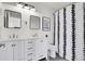 Modern bathroom with double vanity, sleek mirrors, and patterned shower curtain at 2900 N Downing St # 311, Denver, CO 80205