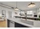 Kitchen island featuring a stainless dishwasher and sink with views into the living and dining area at 2900 N Downing St # 311, Denver, CO 80205