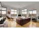 Open living room with large windows, hardwood floors, and comfortable leather furniture at 2900 N Downing St # 311, Denver, CO 80205