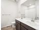 Modern bathroom featuring a double vanity, dark wood cabinets, and a mirror with decorative towel racks at 1947 S Coolidge Way, Aurora, CO 80018