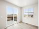 Bright bedroom with sliding glass doors and a window offers access to a private balcony at 1947 S Coolidge Way, Aurora, CO 80018