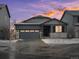 Charming single-Gathering home featuring stone accents, a gray two-car garage, and a beautifully landscaped yard with a colorful sunset at 1947 S Coolidge Way, Aurora, CO 80018