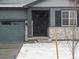 Inviting home exterior showcasing stone accents, covered entryway, a well maintained garage and snow covered landscaping at 1947 S Coolidge Way, Aurora, CO 80018