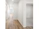 Bright hallway with wood-look flooring, leading to a sunlit living area and a carpeted room at 1947 S Coolidge Way, Aurora, CO 80018