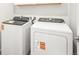 Bright laundry room features modern, white, side-by-side washer and dryer units for convenient chores at 1947 S Coolidge Way, Aurora, CO 80018