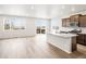 Sun-drenched kitchen and living area featuring hardwood floors and island, blending style and functionality at 1947 S Coolidge Way, Aurora, CO 80018