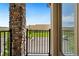 Balcony with brick pillar, black metal railing, and a view of greenery beyond a fence at 2140 Santini Trl # F, Littleton, CO 80129