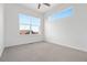 Bright bedroom featuring large windows, neutral carpet, and a ceiling fan for added comfort at 2140 Santini Trl # F, Littleton, CO 80129