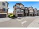 Exterior view of brown townhomes with dark brown garages and beautiful stonework at 2140 Santini Trl # F, Littleton, CO 80129