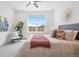 Sunlit main bedroom featuring a decorative ceiling fan, large window, and accent wall decor at 2140 Santini Trl # F, Littleton, CO 80129