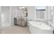 Elegant bathroom features a soaking tub, vanity, and ample natural light for a luxurious experience at 1783 Morgan Dr, Erie, CO 80516
