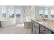 Bright bathroom featuring a soaking tub, walk-in shower, and double vanity for a spa-like experience at 1783 Morgan Dr, Erie, CO 80516