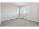 A bright bedroom with plush carpeting and two windows with a view at 1783 Morgan Dr, Erie, CO 80516