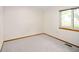 Empty bedroom with neutral carpet, light walls, and a window letting in natural light at 6008 S Van Gordon St, Littleton, CO 80127