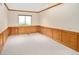 Bedroom featuring wooden paneling, neutral carpet, and a window offering outside views at 6008 S Van Gordon St, Littleton, CO 80127