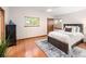 Bright primary bedroom features hardwood floors, large window, and furniture at 6008 S Van Gordon St, Littleton, CO 80127