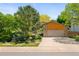 Charming home featuring a stone and wood exterior, a well-manicured lawn, and mature trees at 6008 S Van Gordon St, Littleton, CO 80127