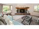 Inviting living room featuring a stone fireplace, bay window, and stylish decor at 6008 S Van Gordon St, Littleton, CO 80127