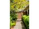 Landscaped yard with lush green bushes, mature trees, and secure brown fence at 6008 S Van Gordon St, Littleton, CO 80127