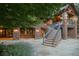 Beautiful backyard featuring brick exterior, stone patio, and staircase leading to an upper level at 4030 E Forbes Ct, Greenwood Village, CO 80121