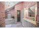 Bright bathroom with tub, glass-enclosed shower, vanity with stone countertop and decorative wallpaper at 4030 E Forbes Ct, Greenwood Village, CO 80121