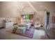 Charming bedroom with vaulted ceiling, window seat, decorative chandelier, and sitting area at 4030 E Forbes Ct, Greenwood Village, CO 80121