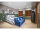 Cozy bedroom with an elegant bed, blue sofa, shuttered windows, and neutral-toned carpeting at 4030 E Forbes Ct, Greenwood Village, CO 80121
