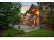 Elegant brick home with meticulous landscaping, stone accents, and a covered outdoor living space at sunset at 4030 E Forbes Ct, Greenwood Village, CO 80121