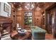 Spacious living room with wood paneling, fireplace, and view of the landscaped backyard at 4030 E Forbes Ct, Greenwood Village, CO 80121