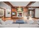 Cozy living room with a stone fireplace, wood paneling, and comfortable seating at 4030 E Forbes Ct, Greenwood Village, CO 80121