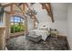 Primary bedroom suite with exposed wood beams, a large window, and comfortable furnishings at 4030 E Forbes Ct, Greenwood Village, CO 80121