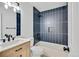 Bathroom boasts wood vanity, modern fixtures, and bold vertical tile at 9605 Carr St, Broomfield, CO 80021